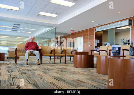 Chirurgie ambulatoire procédure d'attente dans un hôpital; vieil homme caucasien assis dans la salle d'attente; enregistrement du patient. Banque D'Images