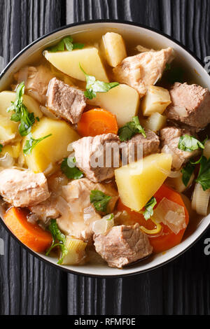 Soupe riche traditionnel Pichelsteiner avec légumes et viande en gros plan un bol sur la table. Haut Vertical Vue de dessus Banque D'Images
