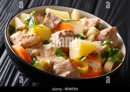 Soupe riche traditionnel Pichelsteiner avec légumes et viande en gros plan un bol sur la table horizontale. Banque D'Images