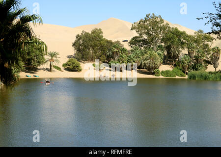 Lagon naturel à Oasis Huacachina ville entourée par de nombreux palmiers et une dune de sable, région Ica du Pérou, Amérique du Sud, la beauté dans la nature Banque D'Images