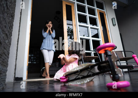 Choqué à la mère à sa fille est tombé de scooter Banque D'Images