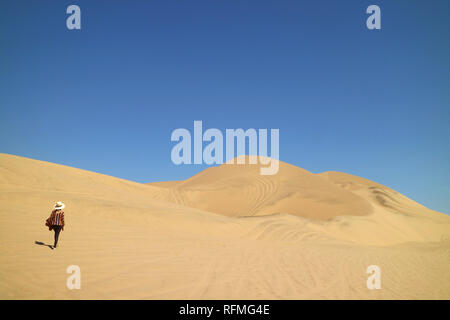 Une dame marche sur les incroyables dunes de sable de désert dans la région de Ica Huacachina du Pérou, Amérique du Sud, la beauté dans la nature Banque D'Images