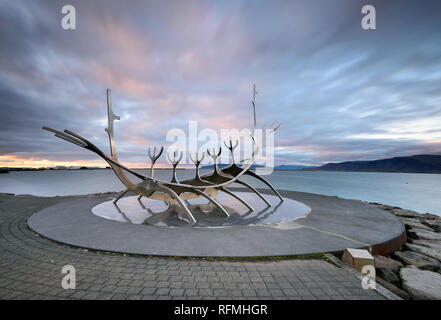 Solfar, Icekand au coucher du soleil. Bien Voyager, monument emblématique de la ville de Reykjavík avec vue sur la mer et les montagnes en arrière-plan, l'Islande Banque D'Images