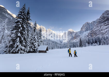 La mère et le fils de randonnée cabane en bois dans un paysage couvert de neige, les montagnes en arrière-plan, les Alpes Juliennes, en Slovénie Banque D'Images