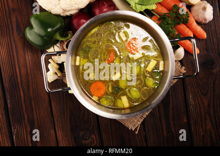 Bouillon avec carottes, oignons divers légumes frais dans un pot - frais colorés clear spring soupe. Cuisine végétarienne paysage rural bouillon Banque D'Images