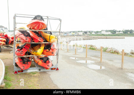 Dans la lumière du soleil, rouge, jaune et blanc des kayaks mis à l'envers sur metal racks de stockage. Stocké dans le canot Brest, France 28 mai 2018. Banque D'Images