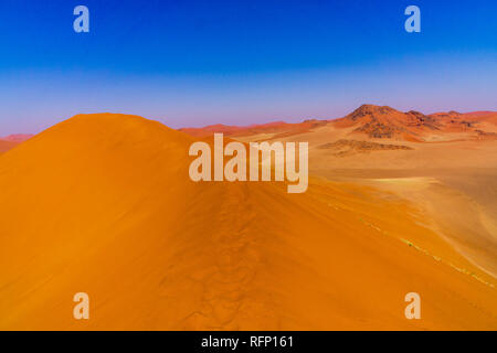 SOUSSUSVLEI, NAMIBIE - 20 juin 2016 : Les gens qui suivent le lever du soleil la forme dune 45 dans la région de Sossusvlei du désert du Namib en Namibie. Banque D'Images