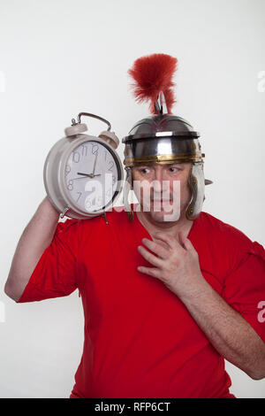 Un soldat romain avec un grand réveil sur le fond blanc. Banque D'Images