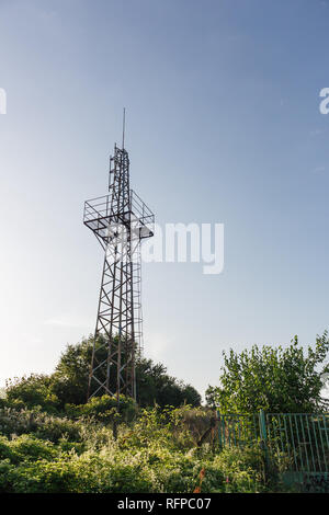 Vue vers le haut de la tour de l'antenne de communication radio abandonné avec des plantes autour de contre le ciel bleu, la Bulgarie. Banque D'Images