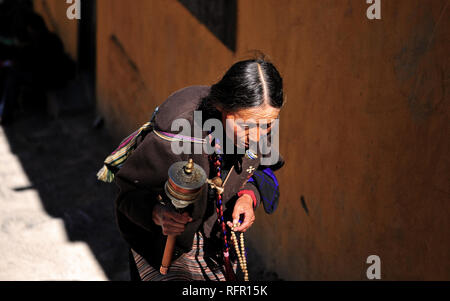 Femme tibétaine montée des escaliers à Lhassa, au Tibet. Banque D'Images