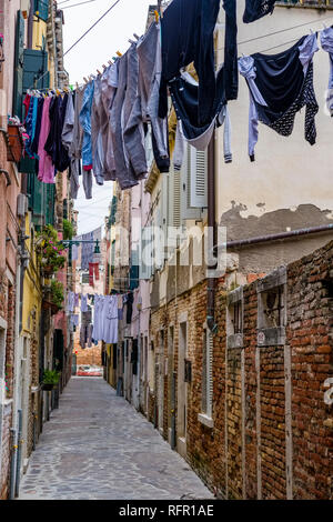 Rues étroites menant à travers les maisons de brique en difficulté de la soi-disant 'Flottante', une blanchisserie est mise en place sur les lignes de lavage Banque D'Images