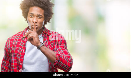 Au cours de l'homme afro-américain de fond isolé demande à être calme avec un doigt sur les lèvres. Silence et secret concept. Banque D'Images