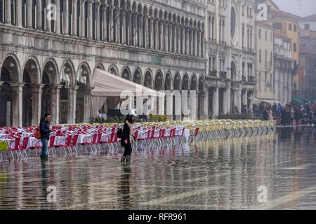 La place San Marco, Piazza San Marco, avec tables et chaises vides d'un restaurant, inondé lors de l'acqua alta Banque D'Images