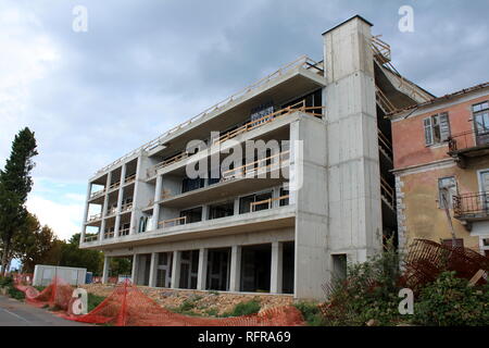 Nouveau bâtiment de l'hôtel en construction à côté de l'abandon a détruit un immeuble entouré de matériaux de construction, casse de clôture et stormy sk Banque D'Images