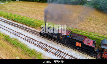 Ariel Vue d'un train de voyageurs en traction à vapeur de pique-nique soufflant de la fumée sur une journée ensoleillée comme vu par un drone Banque D'Images