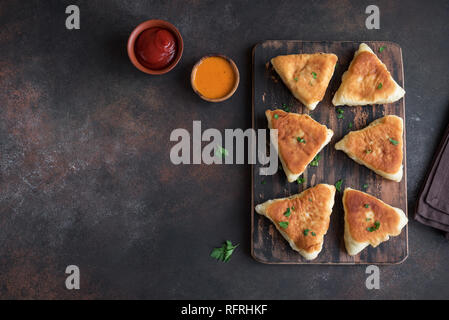 Tartes aux légumes frits, samsa, samosas, echpochmak - viandes traditionnelles tartes farcis végétariens ou pâtés sur fond rustique, copiez l'espace. Banque D'Images
