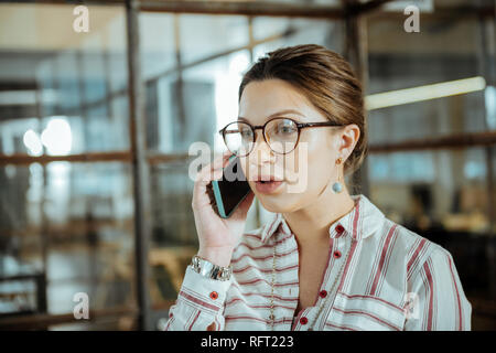 Belle femme brune portant bracelet argenté appelant copain Banque D'Images