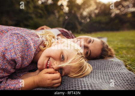 Little girl plaid dans l'avant avec sa mère à l'arrière du parc. Jeune fille avec sa mère à un pique-nique dans le parc automne Banque D'Images