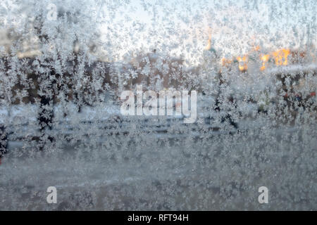 Frost modes sur une vitre. Troubles de vue sur la ville à travers une fenêtre en verre dépoli. Concept de conditions météorologiques extrêmement froides Banque D'Images