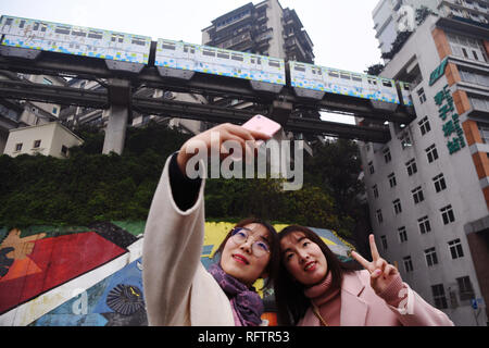 Beijing, Chine. 26 janvier, 2019. Des touristes posent pour une comme selfies sur rail de tramway ligne 2 passe à travers un bâtiment à la station résidence Liziba dans le sud-ouest de la Chine, Chongqing, le 26 janvier 2019. Credit : Wang Quanchao/Xinhua/Alamy Live News Banque D'Images