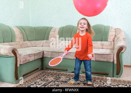 Enfant joue une raquette de tennis et un ballon gonflable Banque D'Images