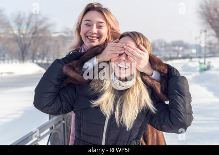 Ses yeux couverts d'une femme avec une autre femme tout en marchant à travers l'hiver alley Banque D'Images