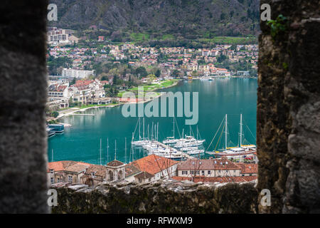 Kotor, Monténégro - Avril 2018 : disponibles dans Kotor Bay marina vue à travers la fenêtre du mur de la forteresse au-dessus de ville Banque D'Images