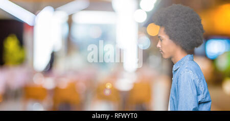 Young african american man with afro hair à côté de beauté, posent avec profil visage naturel avec sourire confiant. Banque D'Images
