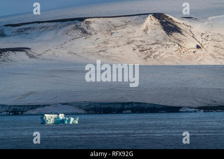 Iceberg flottant dans l'avant du tableau plat montagnes couvertes de glace, l'archipel François-Joseph, Oblast d'Arkhangelsk, de l'Arctique, la Russie, l'Europe Banque D'Images