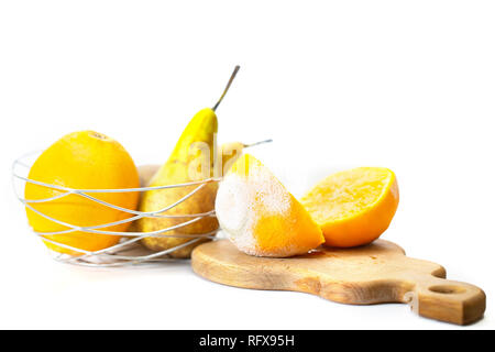 Couper en deux un enfant gâté avec orange et blanc moisissure verte, dans le contexte d'autres fruits Banque D'Images