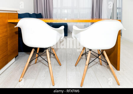 Orange marron en bois moderne est équipée d''armoires dans petit appartement studio avec deux tabourets de bar design intérieur minimaliste et personne dans la maison Banque D'Images