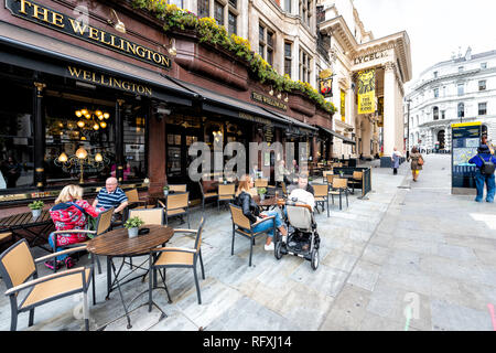 Londres, Royaume-Uni - 12 septembre 2018 : Des gens assis sur rue en route avec la pub Wellington restaurant sign et trottoir dans le Strand à Covent Garden Banque D'Images