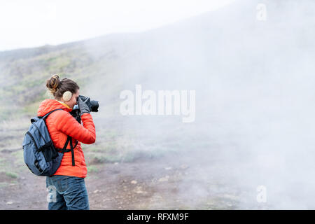 L'Islande, de Reykjadalur Hot Springs Road sentier avec de la vapeur pendant l'évent fumerolles jour d'automne froid en cercle d'or avec des gens femme fille prenant photo Banque D'Images