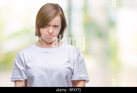 Les jeunes femmes adultes souffrant du syndrome de Down sur fond isolé sceptique et nerveux, fronçant bouleversé parce que de problème. Personne négative. Banque D'Images