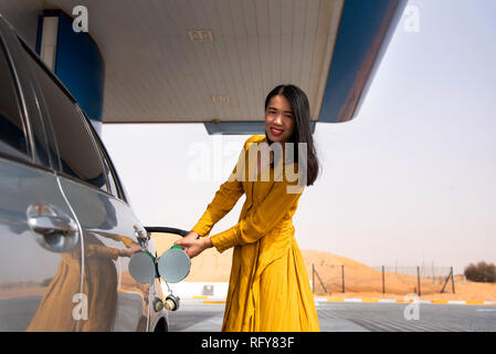 Femme L'ajout d'essence sur le seul poste de carburant Banque D'Images