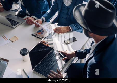 Les gens d'affaires réunion avec des tableaux et des graphiques, l'utilisation ordinateur portable, gros plan, Vue de dessus. Banque D'Images