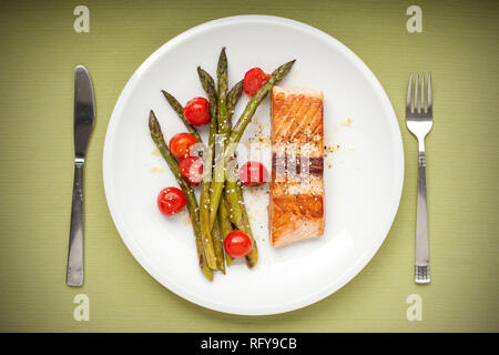 Filet de saumon aux asperges et tomates cerises on white plate Banque D'Images