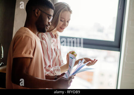 Jeune couple interracial de chefs d'affaires nouvelles a propos de l'idée de partage de projet Banque D'Images