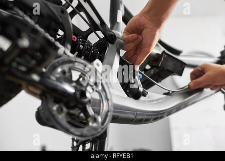 Cropped shot Vue de dessous homme mécanicien travaillant dans un atelier de réparation de vélos, la réparation de vélo moderne des travailleurs Banque D'Images