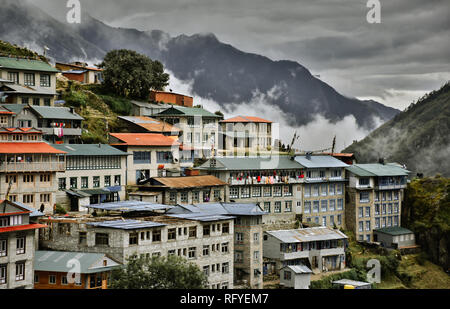 Le mountain village commercial de Namche Bazar au Népal avec ses bâtiments et toits bleus et orange vif au camp de base de l'Everest le long du sentier. Banque D'Images