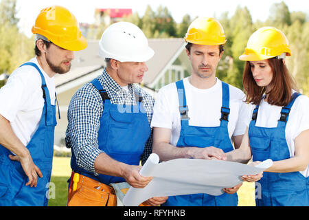 Les travailleurs de la construction avec le plan d'équipe , concept Banque D'Images