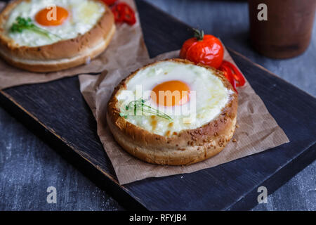Petits pains au fromage fondu et l'oeuf, photo sombre Banque D'Images