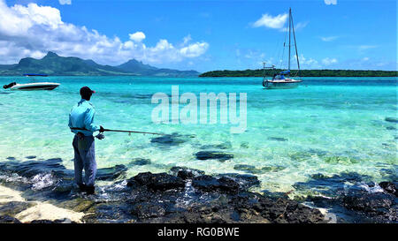 Fisher et voile au point d'Esny beach avec vue sur l'Ile aux Aigrettes, ile Maurice Banque D'Images