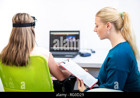 Jeune adolescente et thérapeute pour enfants au cours de l'EEG neurofeedback session. Concept L'électroencéphalographie. Banque D'Images