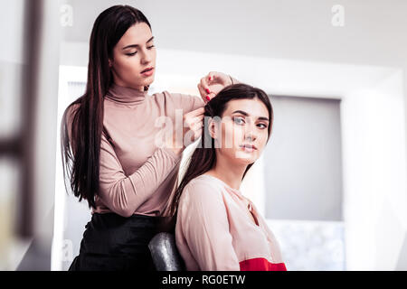 Belle jeune femme ayant sa coiffure fait Banque D'Images