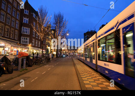 Amsterdam, Pays-Bas - 06 janvier 2019 : la circulation sur la rue décoré de lumières de Noël en soirée Banque D'Images