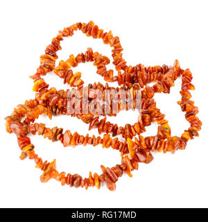 Chaîne de perles d'ambre baltique isolé sur fond blanc. Collier ambre orange vif de matières perles en un tas. Banque D'Images