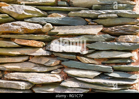 Ardoise empilées sur un mur en pierre rustique Banque D'Images