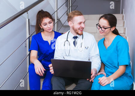 Les soins de santé. Un groupe d'étudiants en médecine étudiant communique en face d'un ordinateur portable. Discussion sur le diagnostic. Banque D'Images