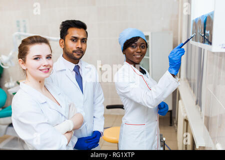 La santé et les soins de santé. Un groupe multinational de dentistes examine les rayons x en présence d'un patient. La pratique à une université médicale. Banque D'Images